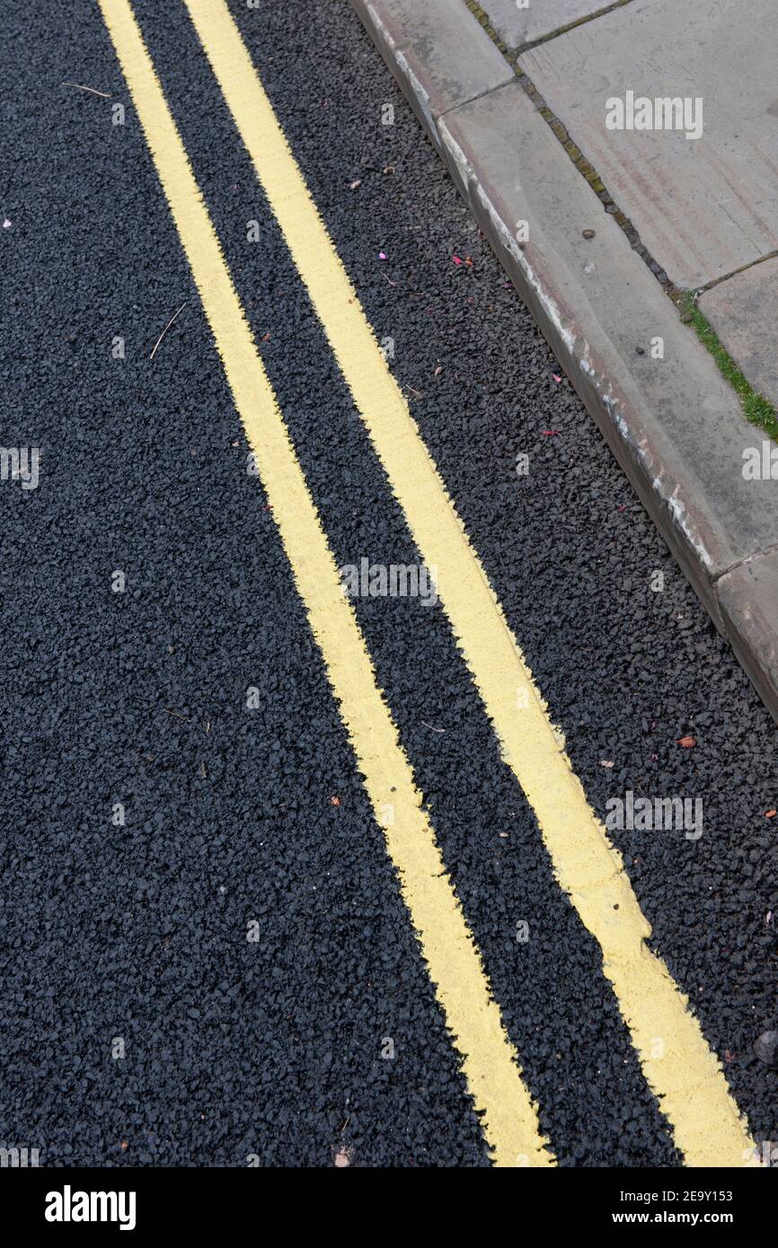 Lignes jaunes doubles fraîchement peintes sur une route tarmac Banque D'Images