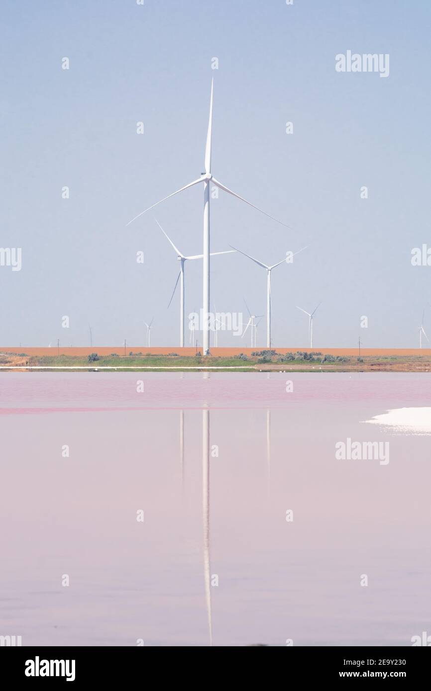 Éoliennes se reflétant dans des plaines salées. Eau colorée aux algues roses. Orientation verticale. Banque D'Images