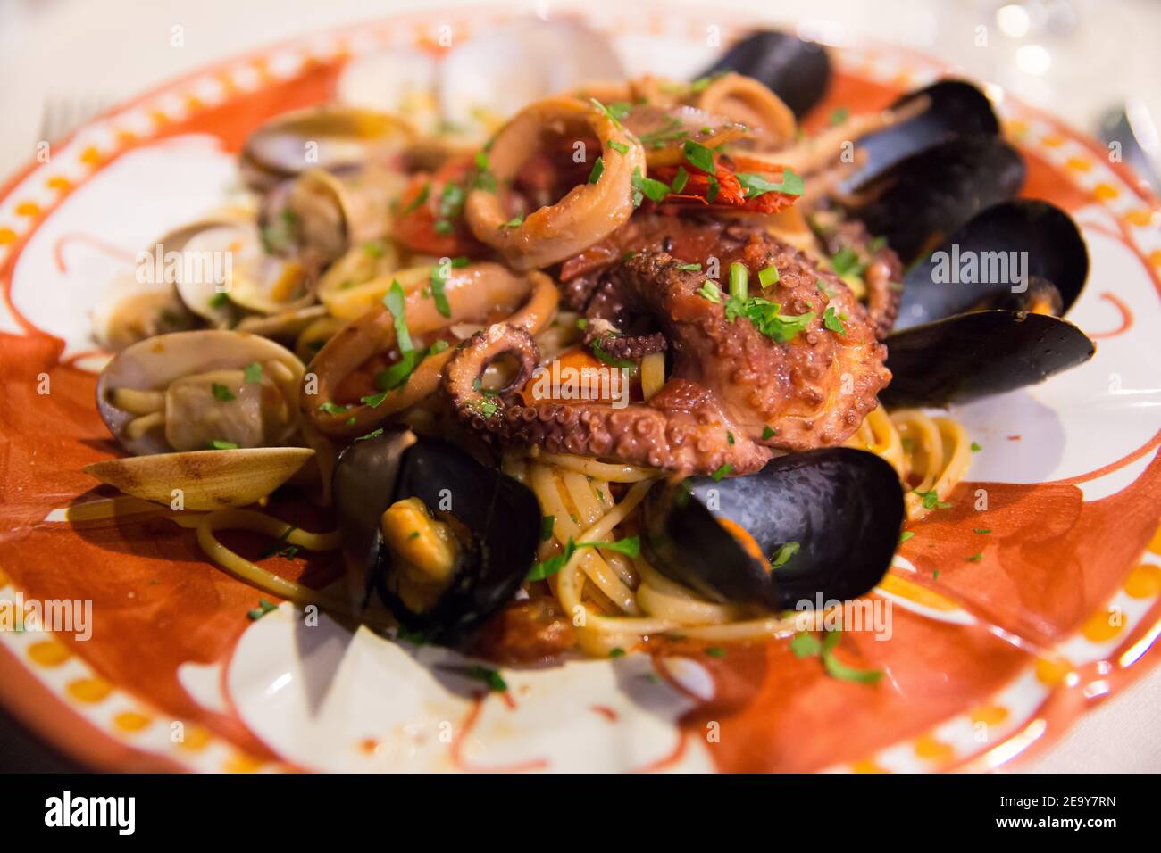 Cuisine italienne : spagetti de fruits de mer avec poulpe grillée et moules sur une plaque en céramique peinte à la main de l'île de Capri, mer Tyrrhénienne, Italie Banque D'Images