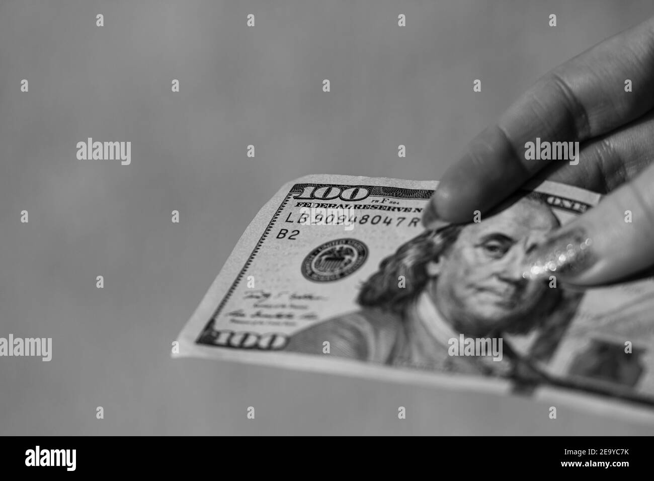 Mains donnant de l'argent comme un pot-de-vin ou des conseils. Détenir des billets de banque en dollars américains sur un fond flou, la monnaie américaine Banque D'Images