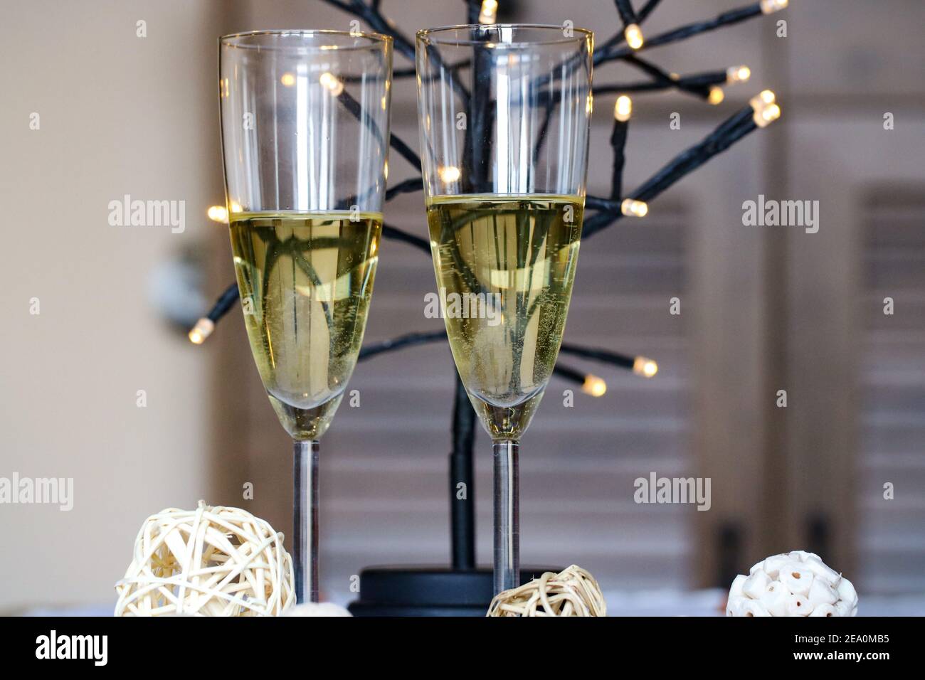 Deux verres de vin blanc et des lumières pour une célébration Banque D'Images