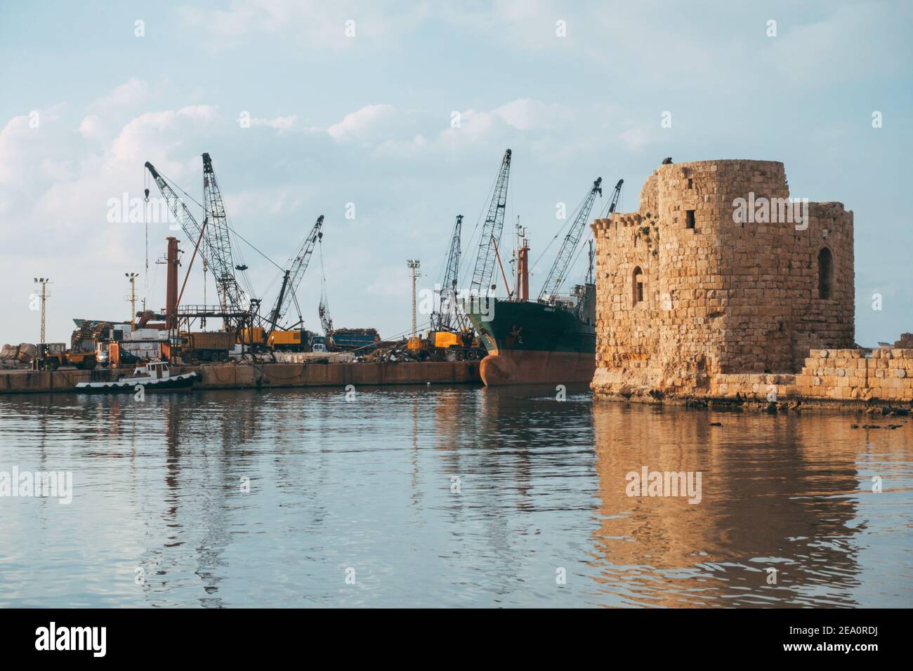 Un navire de déchets se charge derrière le château de la mer de Sidon à Sidon, au Liban Banque D'Images