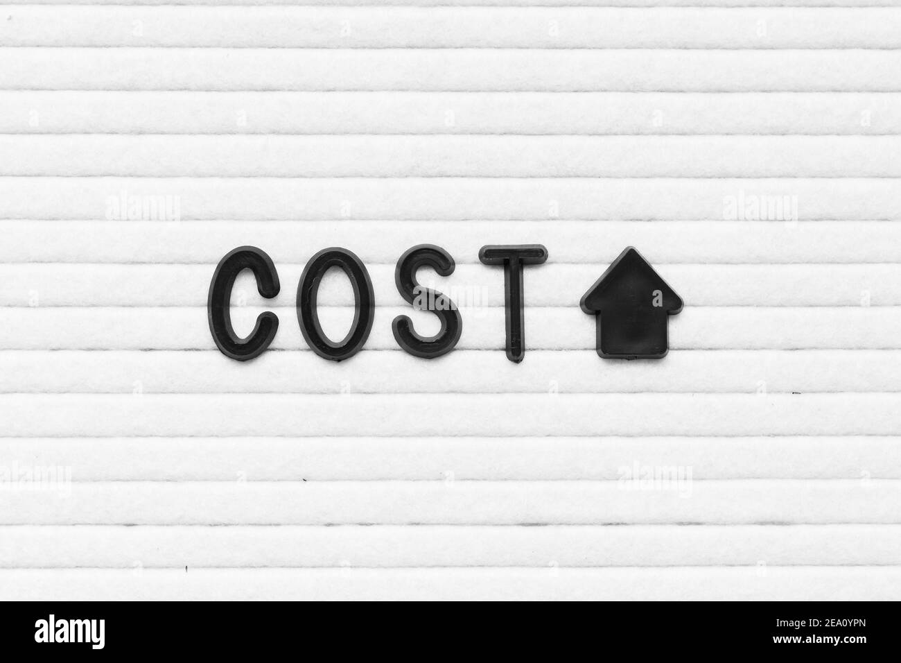 Lettre de couleur noire dans le mot coût avec flèche vers le haut activée fond en feutre blanc Banque D'Images