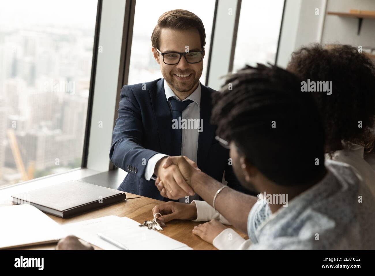 Agent homme professionnel confiant vendre maison à des clients de famille africains Banque D'Images