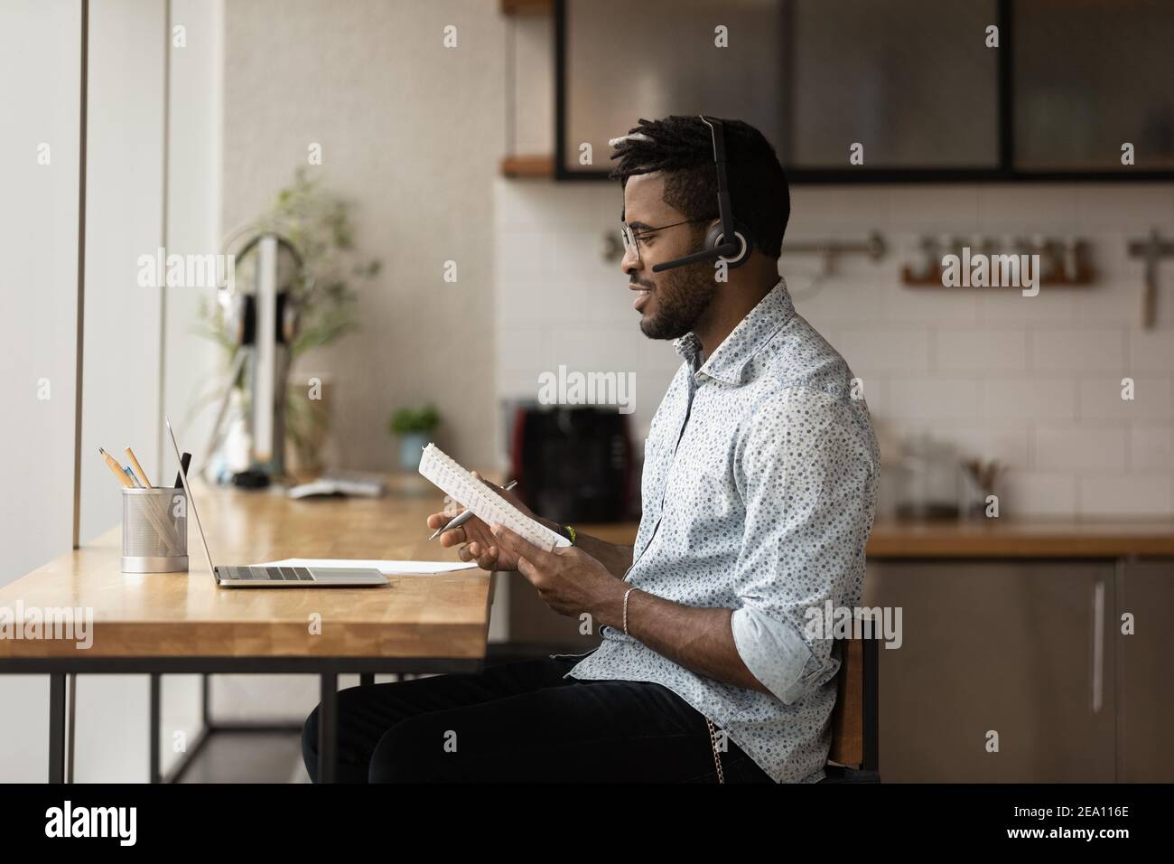 Étudiant noir dans le casque discutant du test via une conférence en ligne Banque D'Images