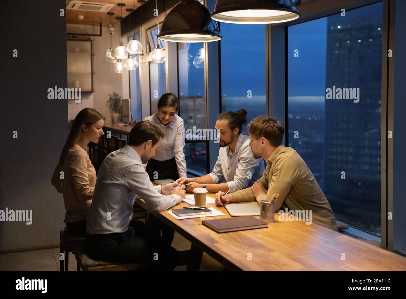 Une équipe d'entreprise multiethnique partage des documents de travail sur le briefing à l'aide de gadgets Banque D'Images