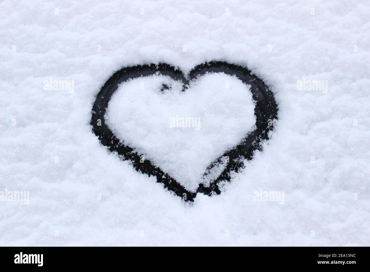 Signe d'amour en forme de coeur, dessiné sur une glace enneigée sur un lac d'hiver avec espace de copie. Toile de fond romantique Banque D'Images