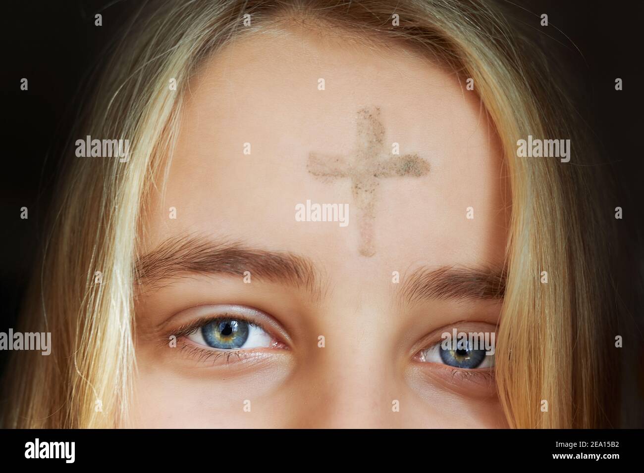 Fille avec croix faite de cendres sur le front. Concept de mercredi de cendres. Banque D'Images