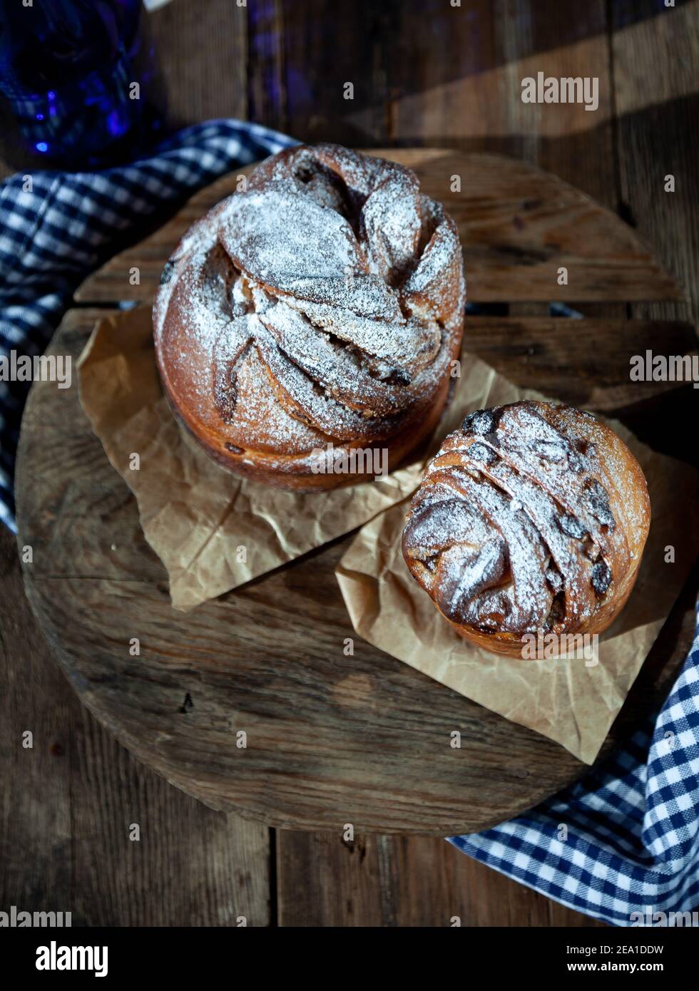 Kraffin gâteau de Pâques. Kraffins aux raisins secs, fruits confits et graines de pavot, arrosés de sucre en poudre. Gros plan de gâteau maison. Brut. Banque D'Images