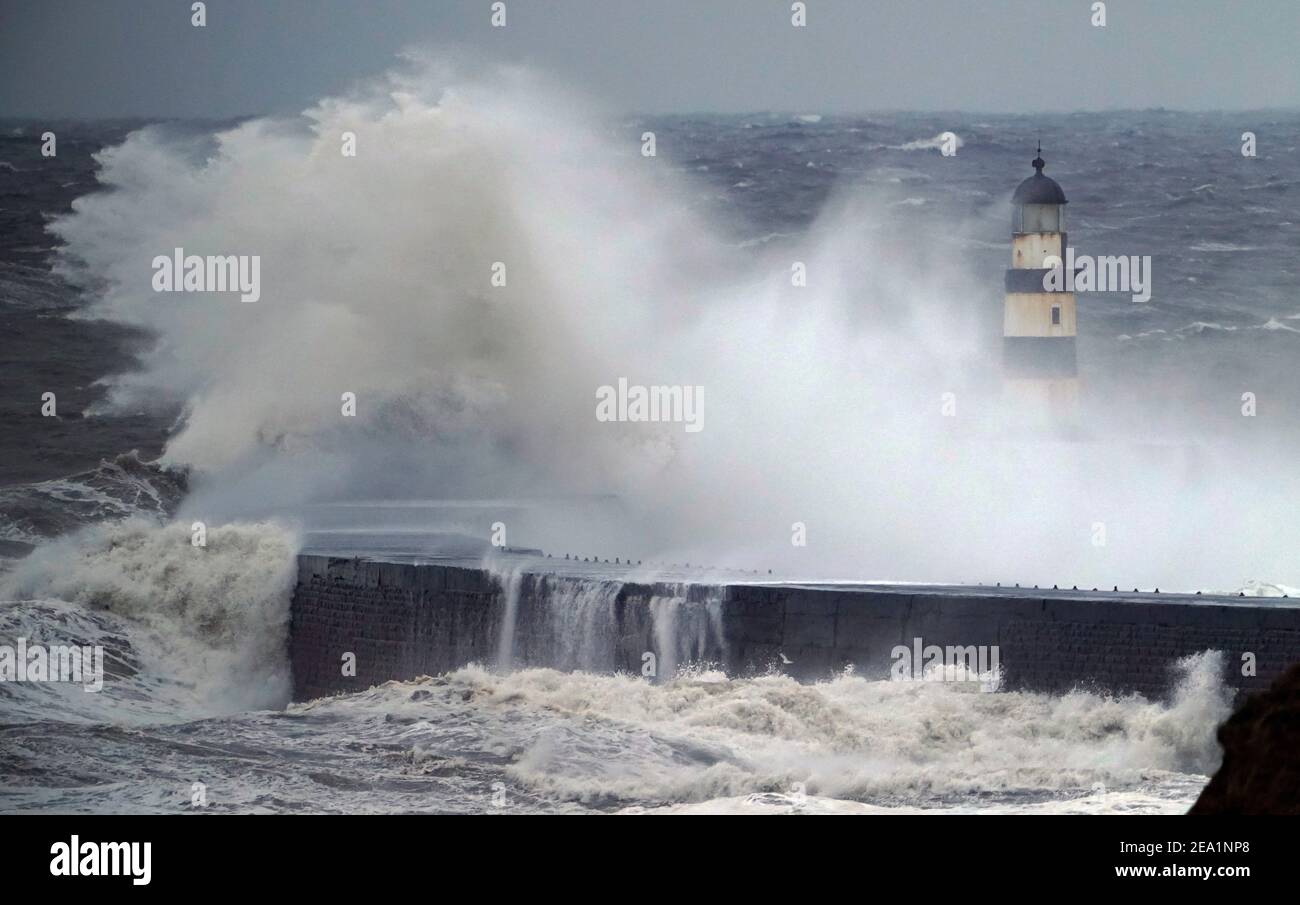 D'énormes vagues se sont écrasant au-dessus du phare de Seaham à Durham, tandis que Storm Darcy envoie des conditions artiques de l'est, tandis que des vents amèrement froids s'envenirent dans une grande partie du pays. Date de la photo: Dimanche 7 février 2021. Banque D'Images