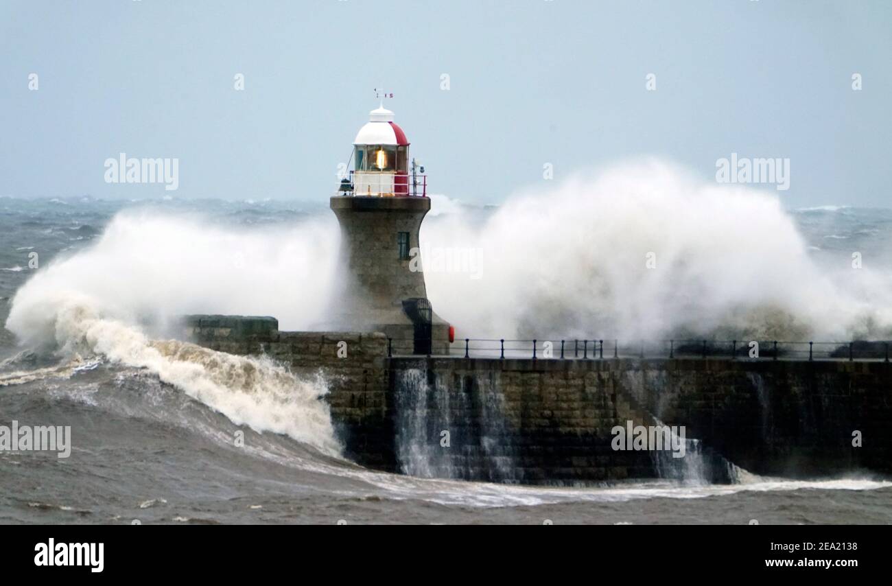 Une vague atteint le phare de South Shields alors que Storm Darcy arrive, apportant des conditions artiques de l'est, alors que des vents amèrement froids s'approdent d'une grande partie de la nation. Date de la photo: Dimanche 7 février 2021. Banque D'Images