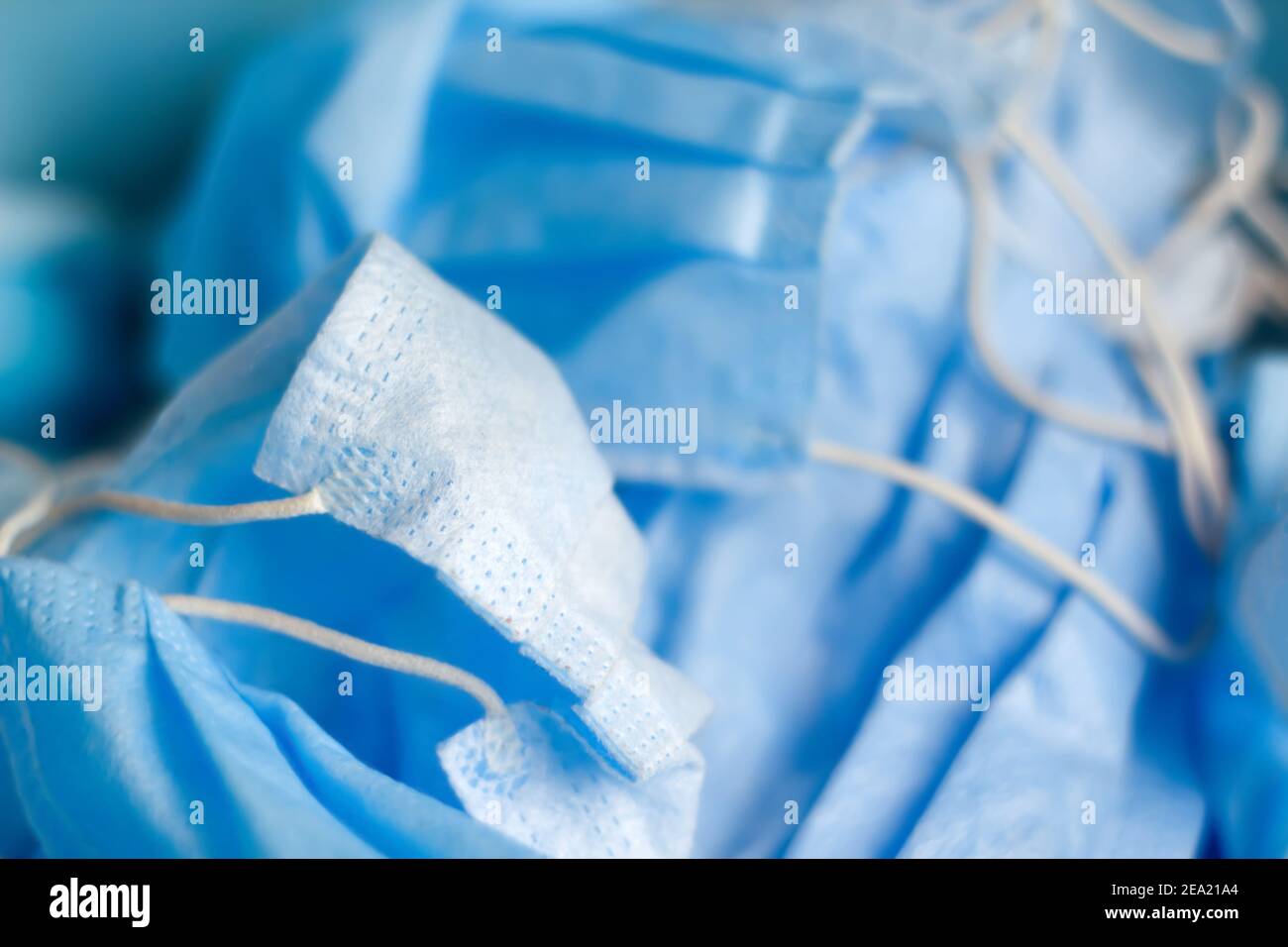 Appliquer un effet de flou au masque facial de protection sur fond bleu. Toile de fond médicale. Beaucoup de masc chirurgical. Beaucoup de masques de protection. Mise au point sélective Banque D'Images
