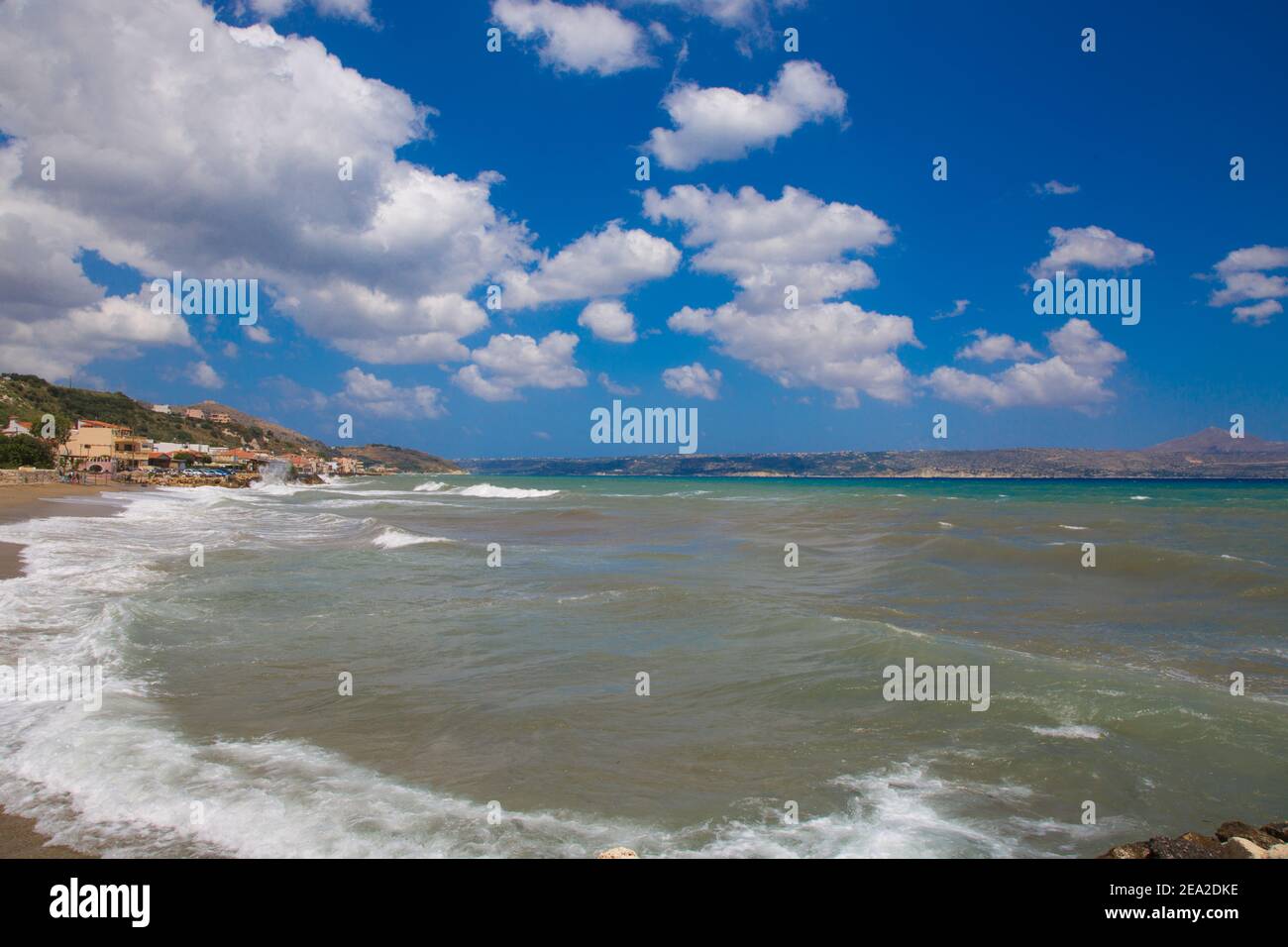 Crète plage Kalyves. Parasols et chaises longues bleus et jaunes sur fond d'une belle mer bleue par une journée ensoleillée. Plage publique de Kalyves en Crète Banque D'Images