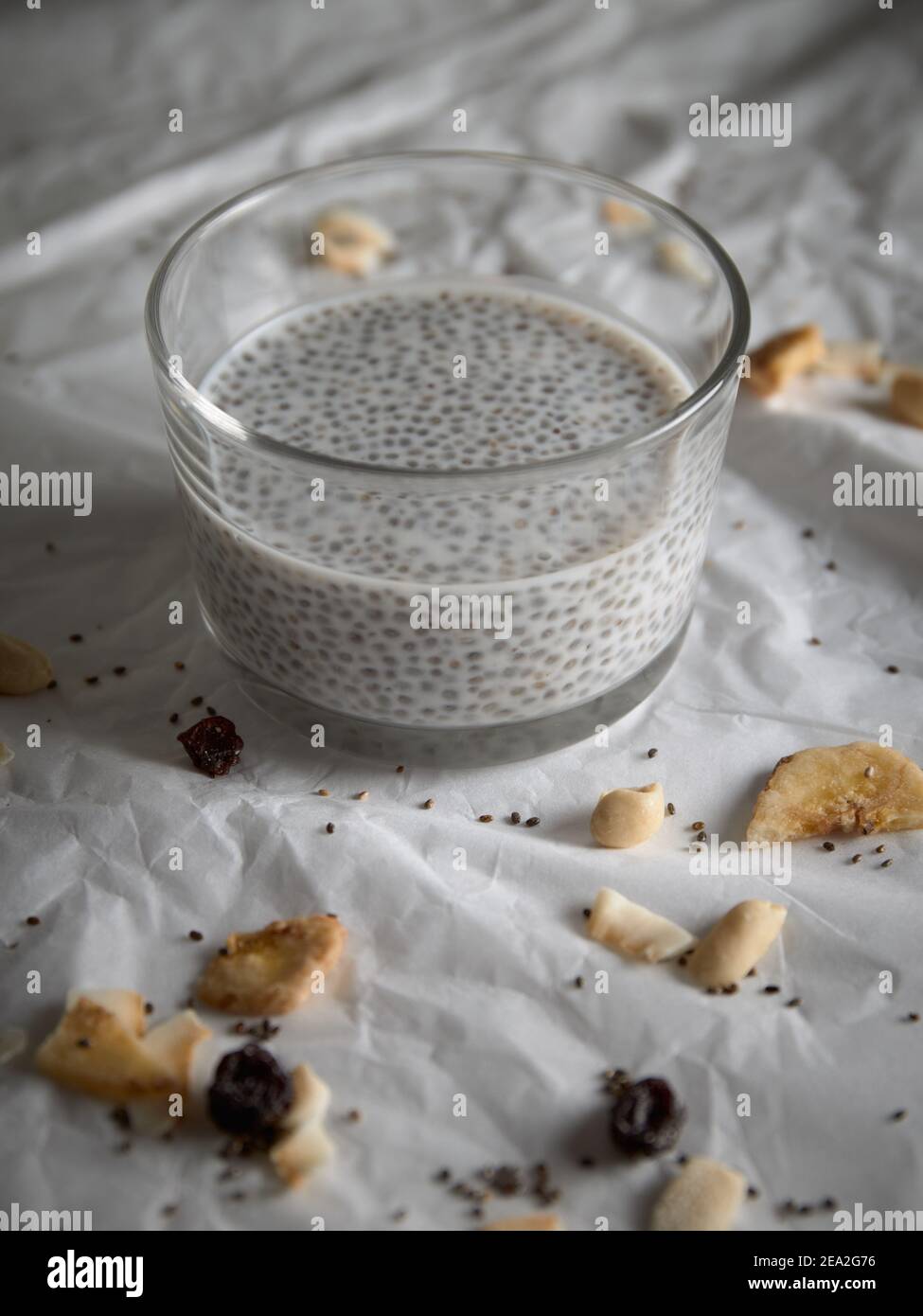 verre de graine de chia pudding sur fond de papier blanc. banane séchée et graines Banque D'Images