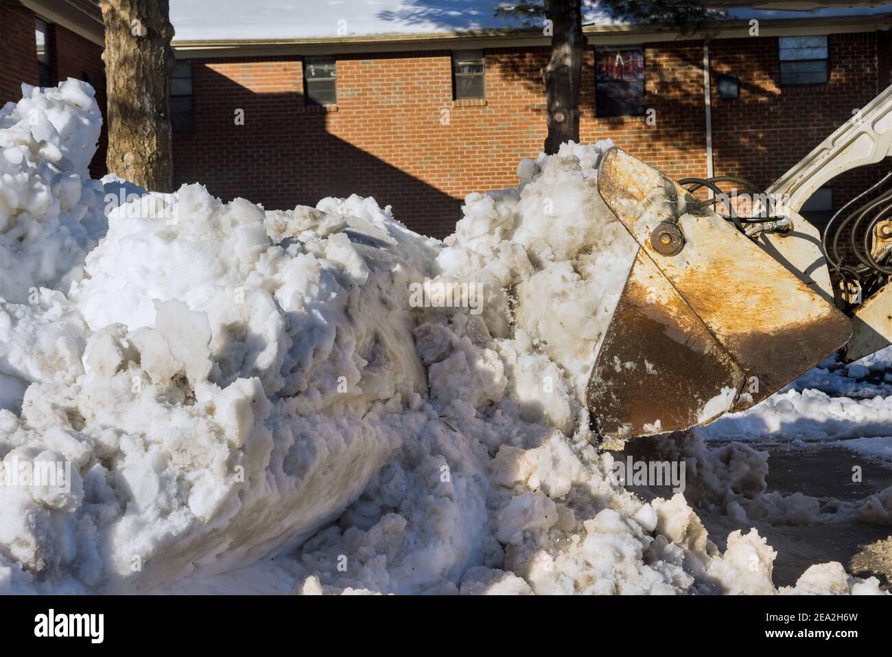 L'équipement de déneigement sur un parking pour voitures route dans l'arrière-plan de la neige d'hiver Banque D'Images