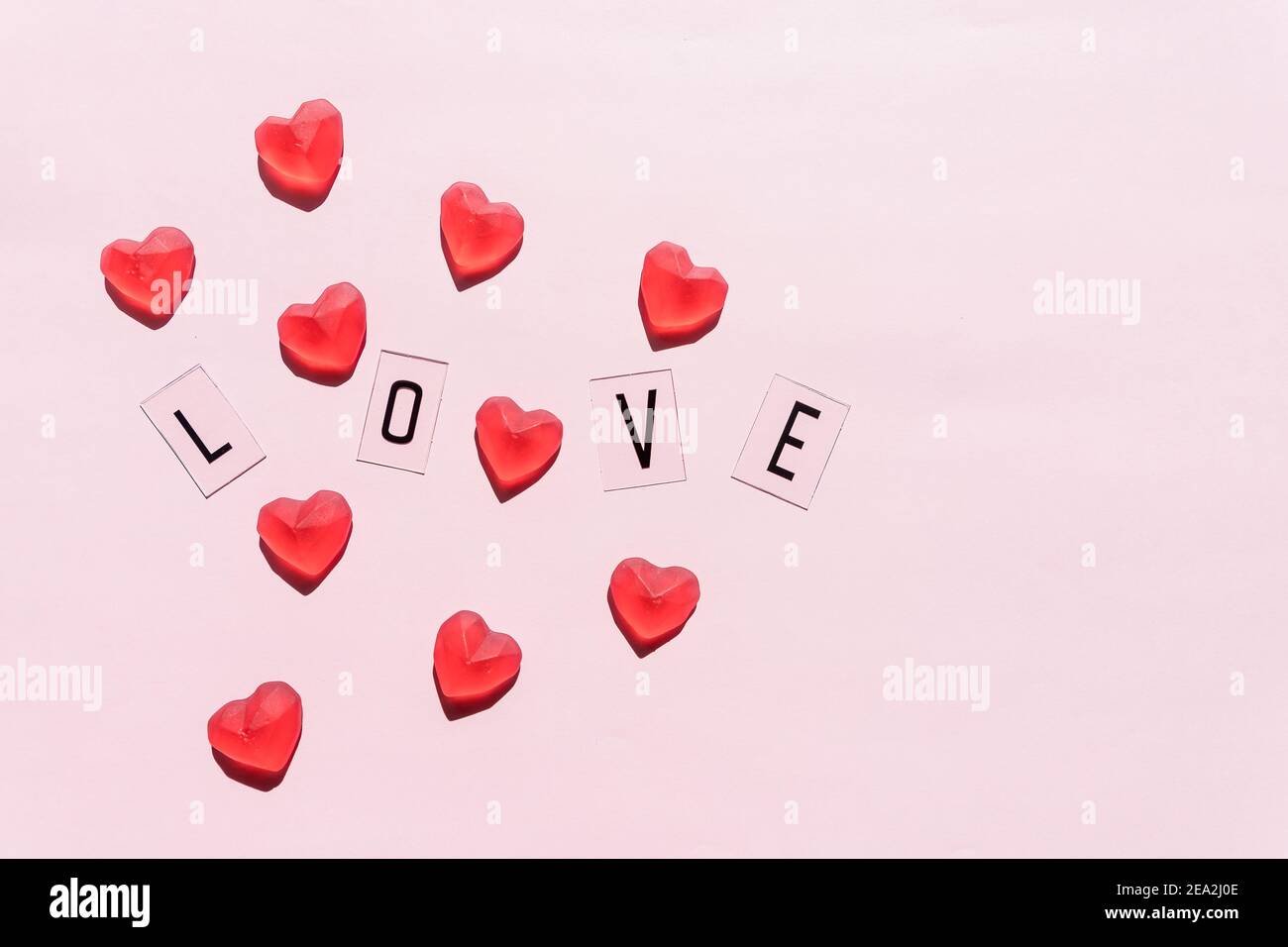 Banner.the Word Love.Black lettres Love with Red Hearts.on Pink background.Valentine's day. Émotions aimantes et positives. Toile de fond sentiments. Exclusif Banque D'Images