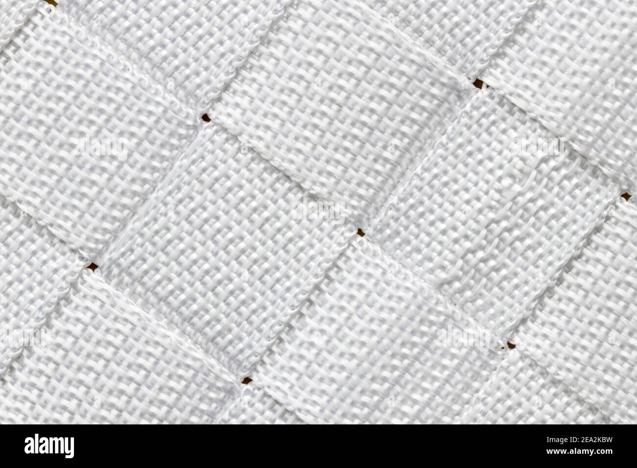 Motif diagonal abstrait alterné composé de carrés de nylon blanc tissé. Banque D'Images