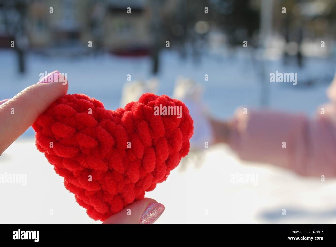 Coeur rouge dans les mains comme symbole de l'amour, symboles tricotés Banque D'Images