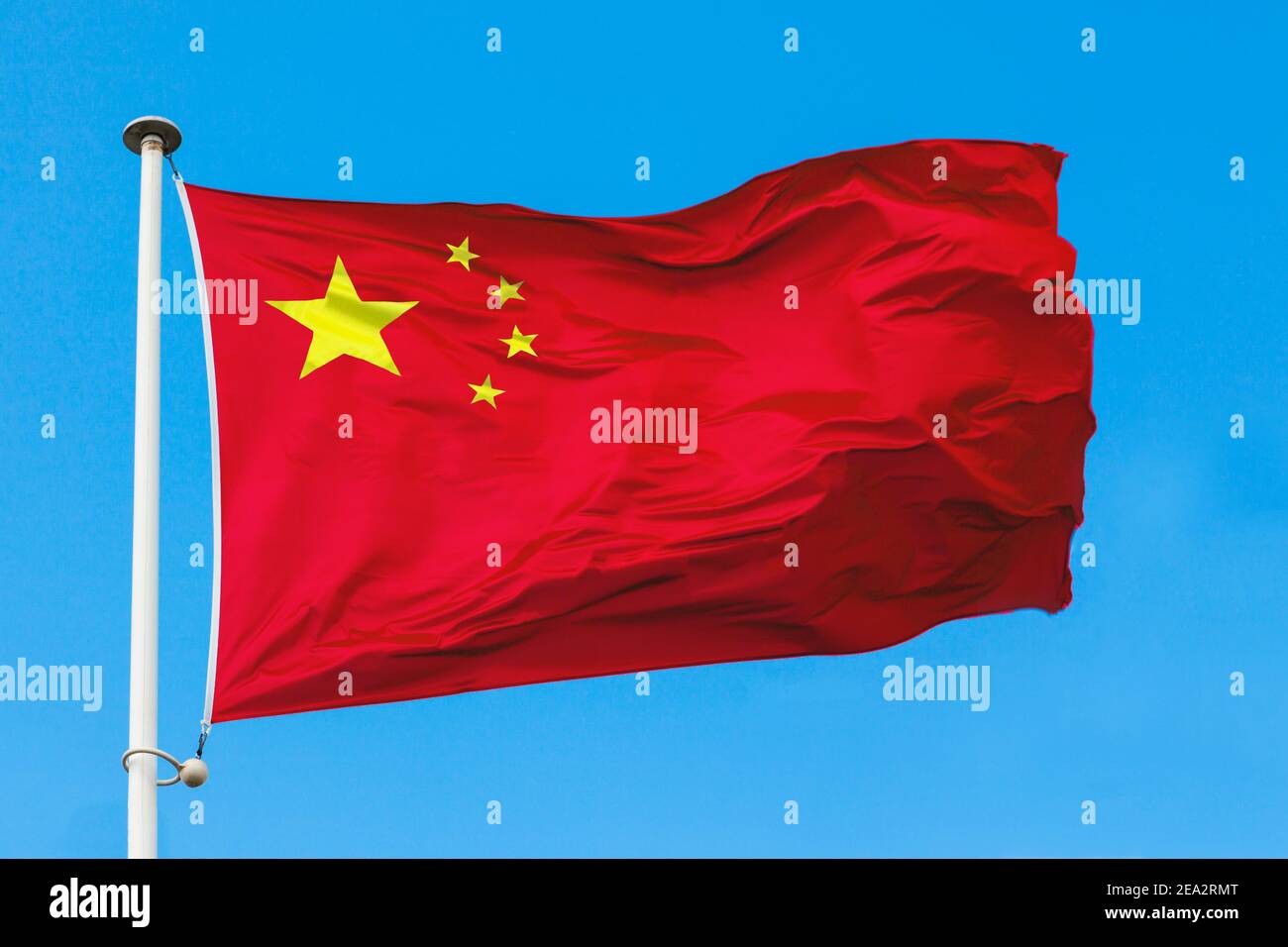 Le drapeau de la Chine en gros plan. Drapeau chinois rouge à cinq étoiles contre le ciel bleu. Banque D'Images