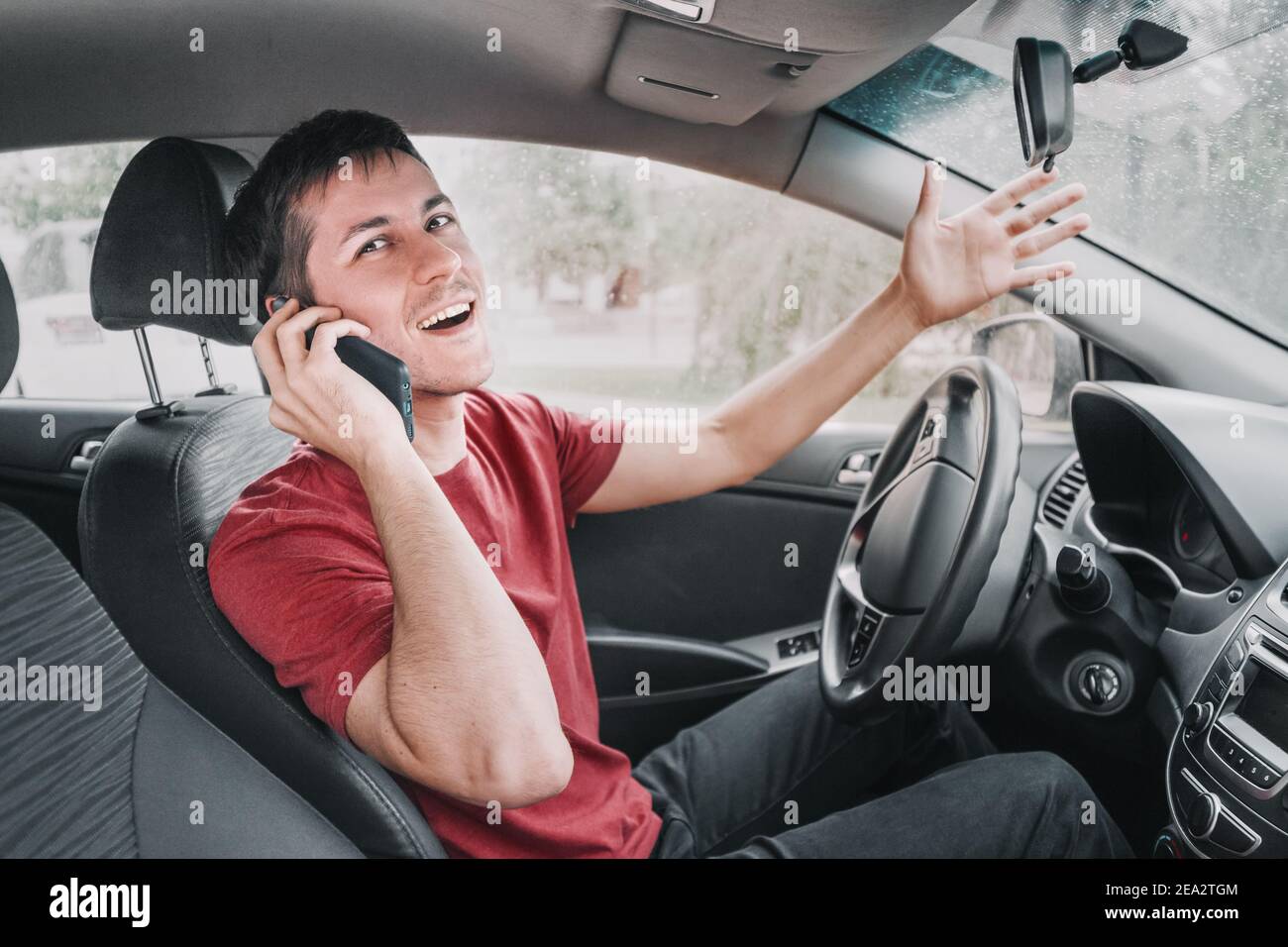 le conducteur de chatterbox conduit et parle à un ami au téléphone en même temps. Crée une situation de route dangereuse et le risque d'accident dû Banque D'Images