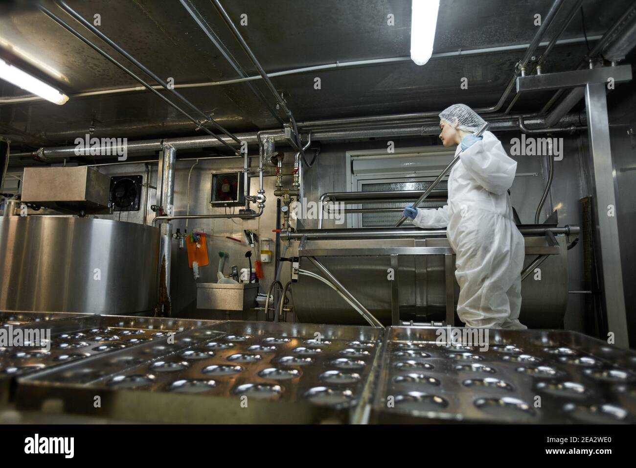 Image d'arrière-plan à faible angle du tapis transporteur industriel dans une usine de production alimentaire propre avec une femme imreconnaissable, espace de copie Banque D'Images
