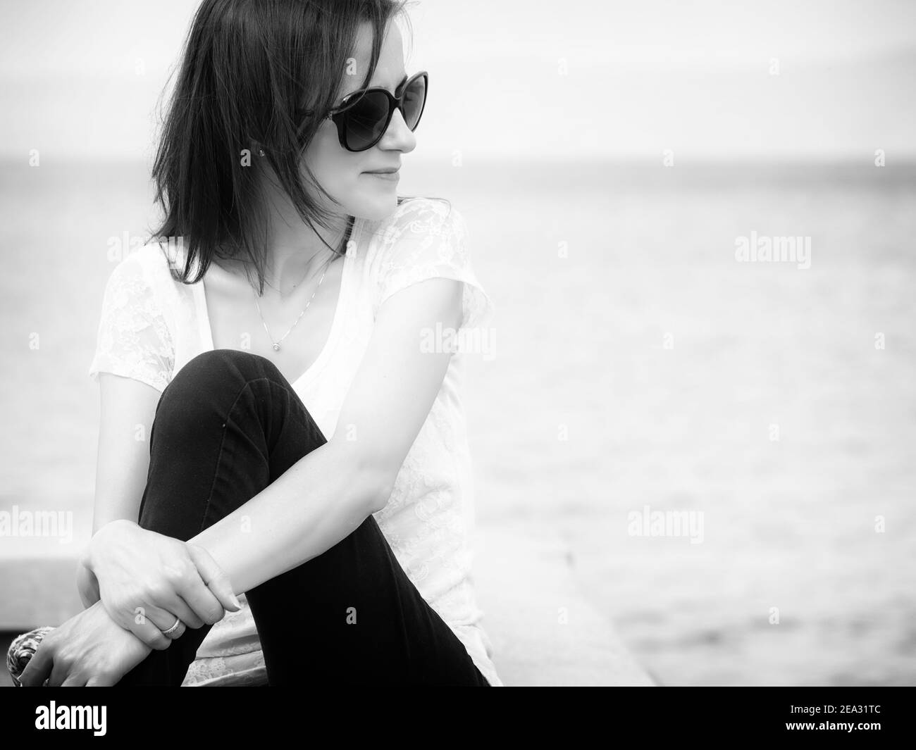 Portrait noir et blanc de la jeune femme caucasienne avec grand Lunettes de soleil au bord du lac de Bolsena Banque D'Images