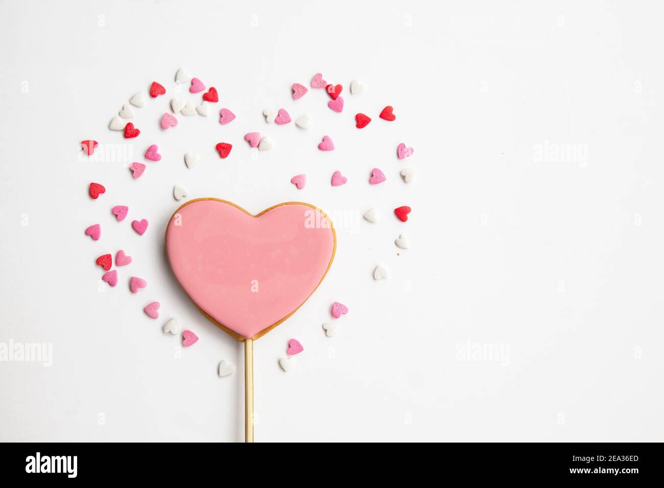 Coeur doux sur un bâton sur fond blanc. Petits gâteaux roses pour la Saint-Valentin Banque D'Images