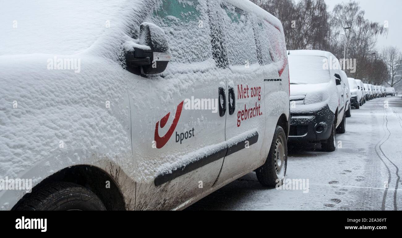 Pare-brise / pare-vent et vitres de voiture des véhicules de livraison Belge Bpost garés couverts de neige par temps froid en hiver, Belgique Banque D'Images