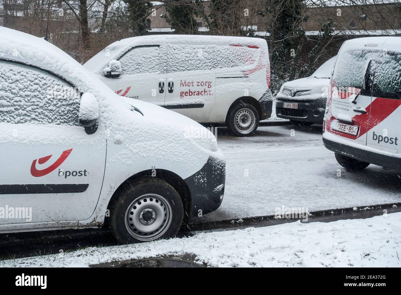 Pare-brise / pare-vent de voiture des véhicules de livraison de poste de poste de Belge garés couverts de neige pendant le temps froid en hiver, Belgique Banque D'Images