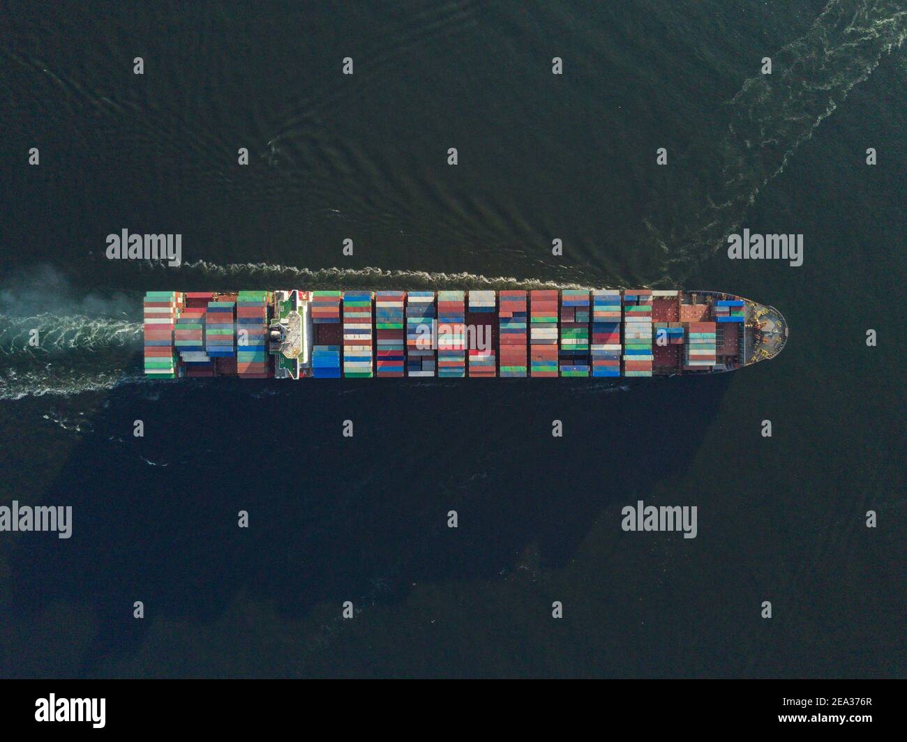 Vue aérienne depuis un drone d'un navire à conteneurs, transportant des conteneurs en vrac à travers l'une des voies de navigation les plus achalandées d'Asie - le canal de Lamma - entre Aberdeen sur l'île de Hong Kong et l'île de Lamma. L'itinéraire est si occupé que chaque navire a besoin d'un bateau-pilote à destination et en provenance des quais pour naviguer dans cette partie de la mer. © Olli Geibel Banque D'Images