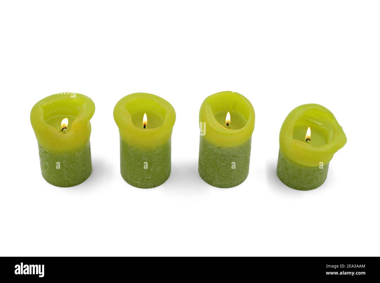 différentes tailles de bougies vertes allumées sur un fond blanc, vue du dessus Banque D'Images