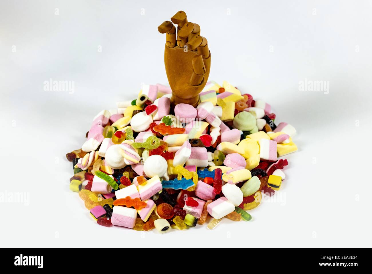 Sauve-moi des sucres! Une main en bois sortant d'une montagne de bonbons  Photo Stock - Alamy