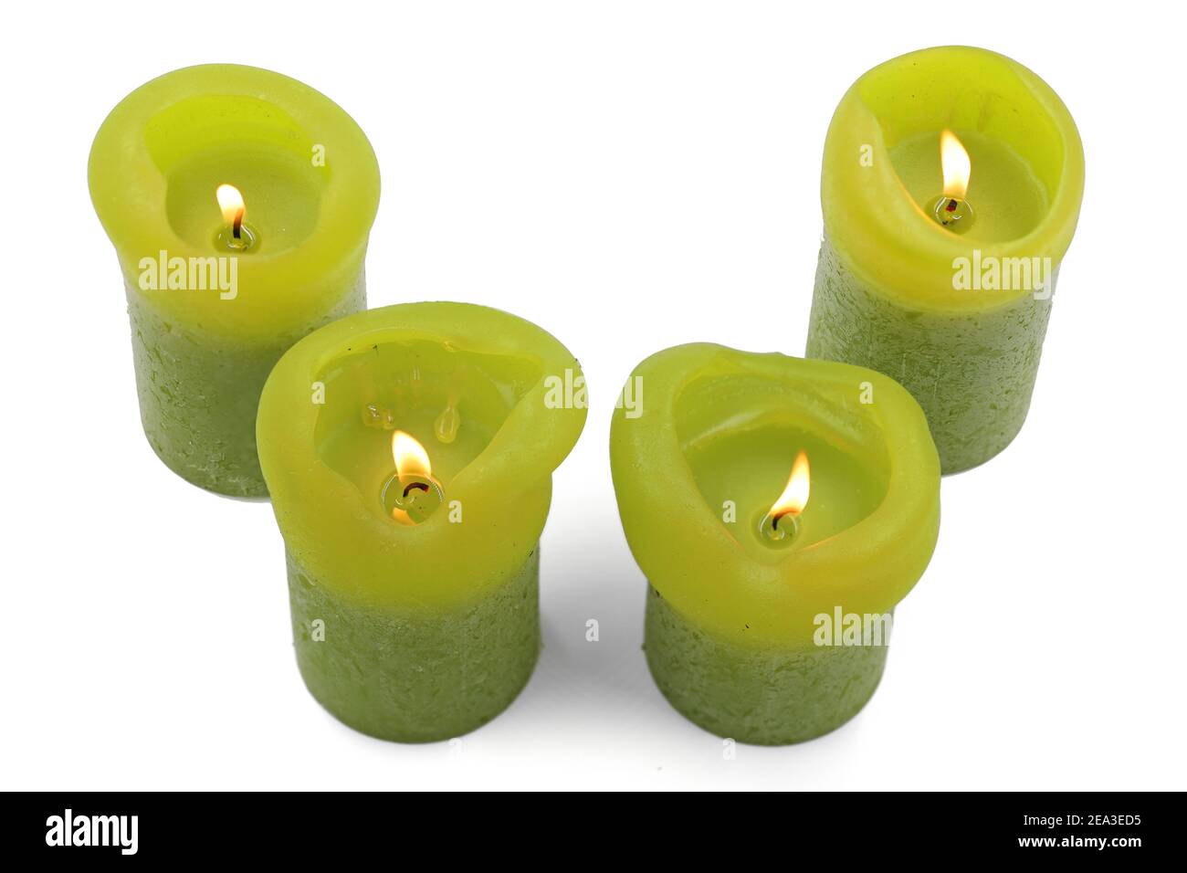 différentes tailles de bougies vertes allumées sur un fond blanc, vue du dessus Banque D'Images
