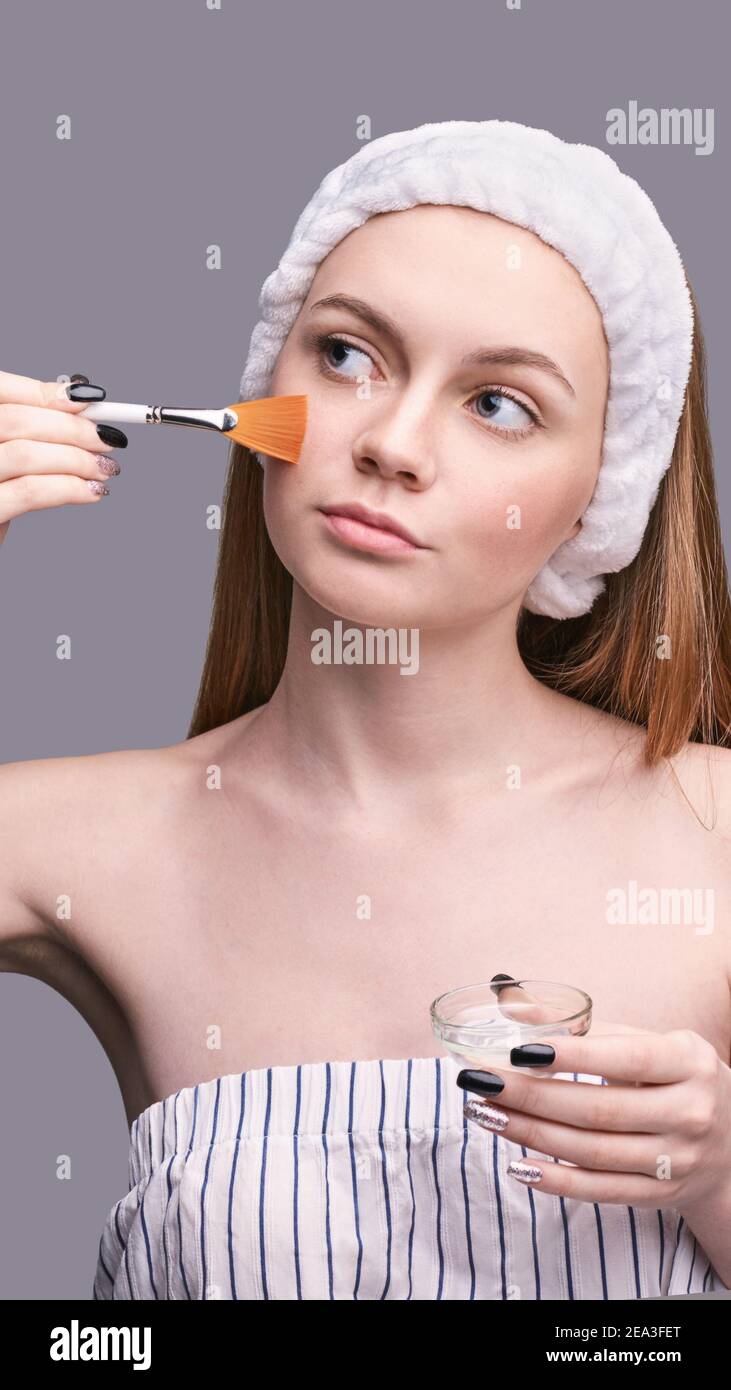 Gommage du visage. Jolie petite fille et brosse de cosmétologie. Masque  anti-acné. Soins de la peau à domicile Photo Stock - Alamy