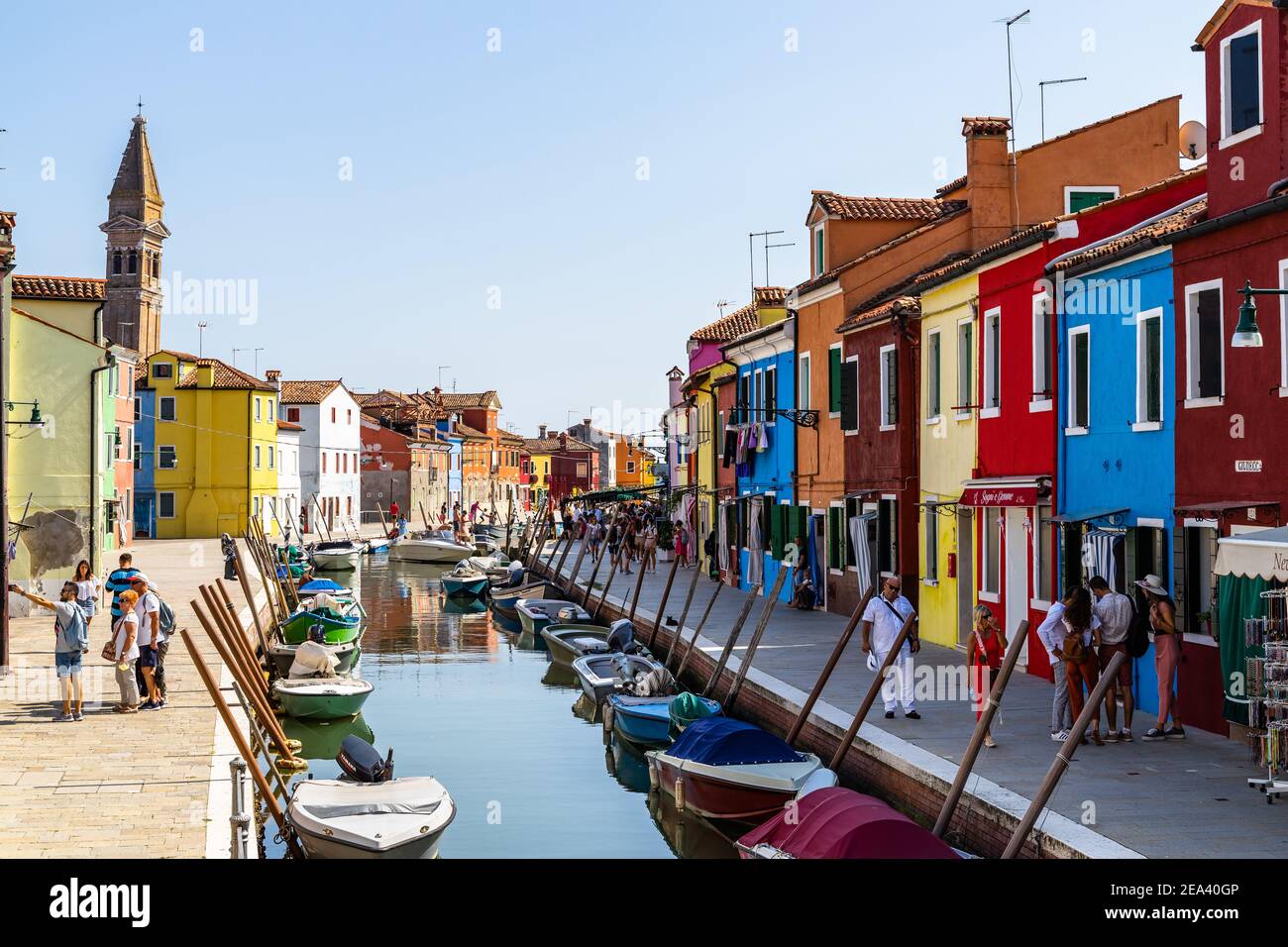 Burano, Italie, 2020 septembre – les touristes se baladent le long d'un canal typique de Burano avec des maisons colorées et une boutique de cadeaux Banque D'Images