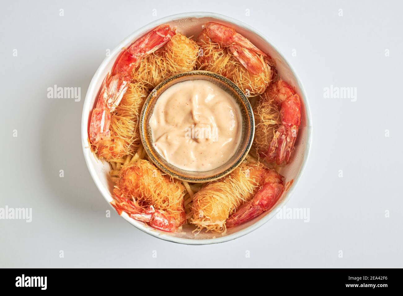 Vue aérienne d'un cube de crevettes frites enveloppées de pâtes Kataifi et servies avec une sauce dragon. Banque D'Images