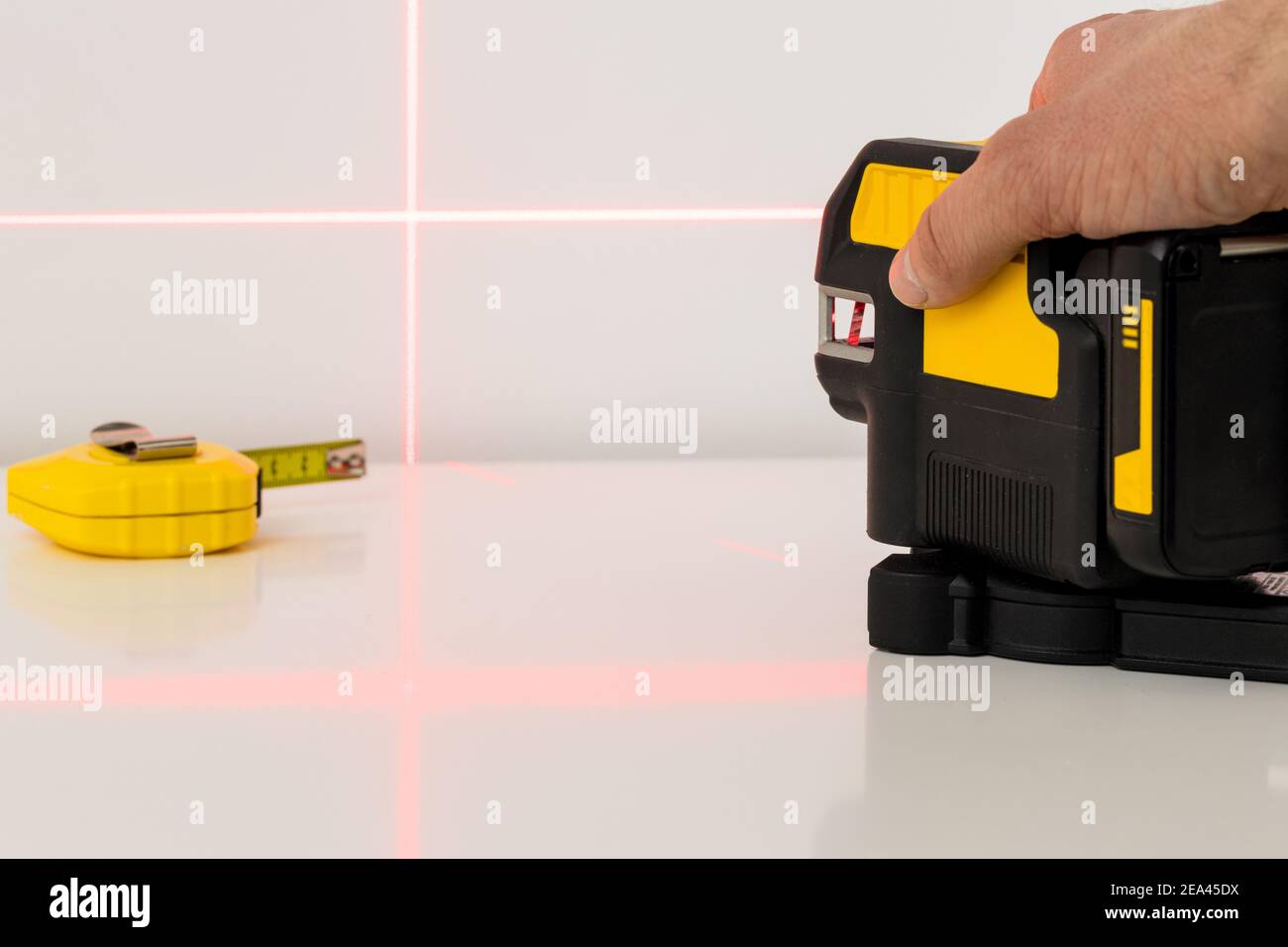 L'installateur utilise un laser électronique pour mesurer les angles et lignes droites Banque D'Images