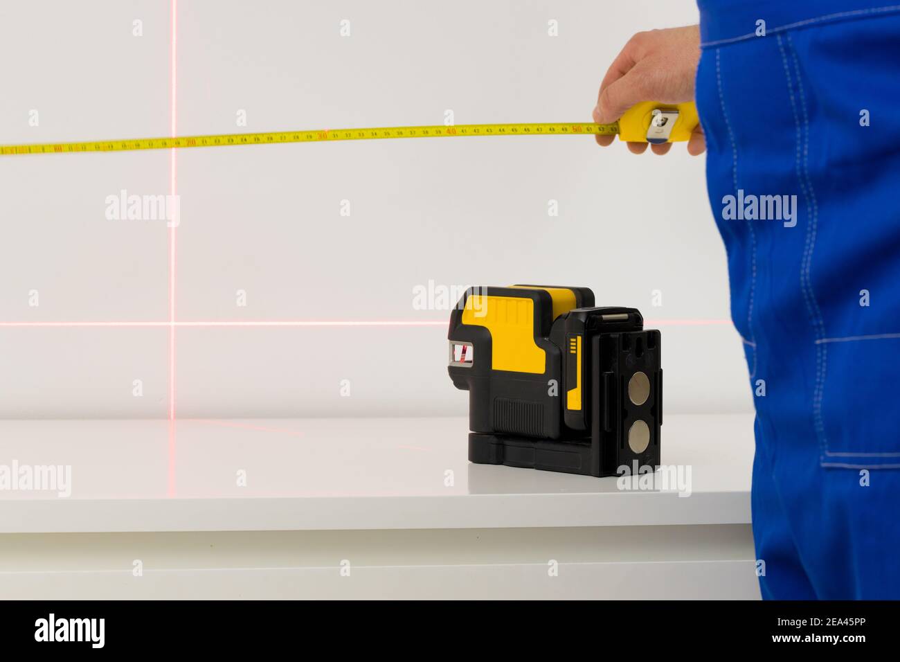 L'installateur utilise un laser électronique pour mesurer les angles et lignes droites Banque D'Images