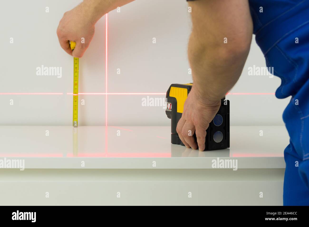 L'installateur utilise un laser électronique pour mesurer les angles et lignes droites Banque D'Images