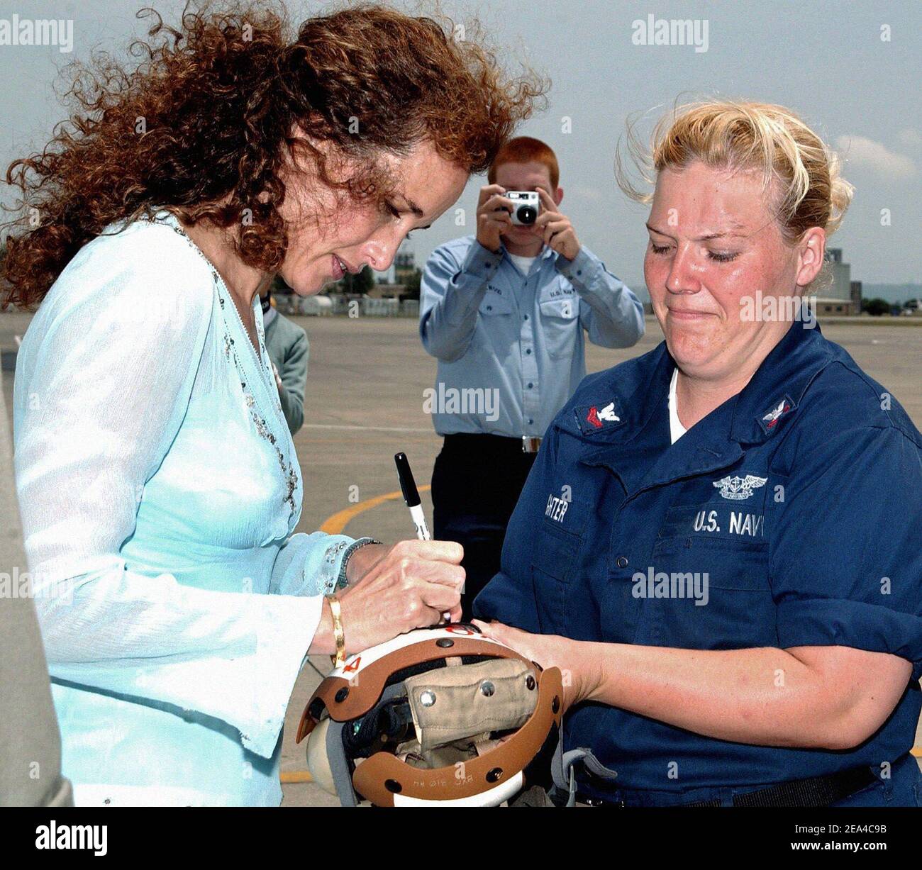 L'actrice américaine Andie McDowell autographe une photo pour Laura Delaughter, affectée à l'escadron de soutien au combat des hélicoptères quatre (HC-4) en visitant la base aérienne navale de Sigonella en Sicile, en Italie, le 13 juin 2005. Photo par USN via ABACA. Banque D'Images