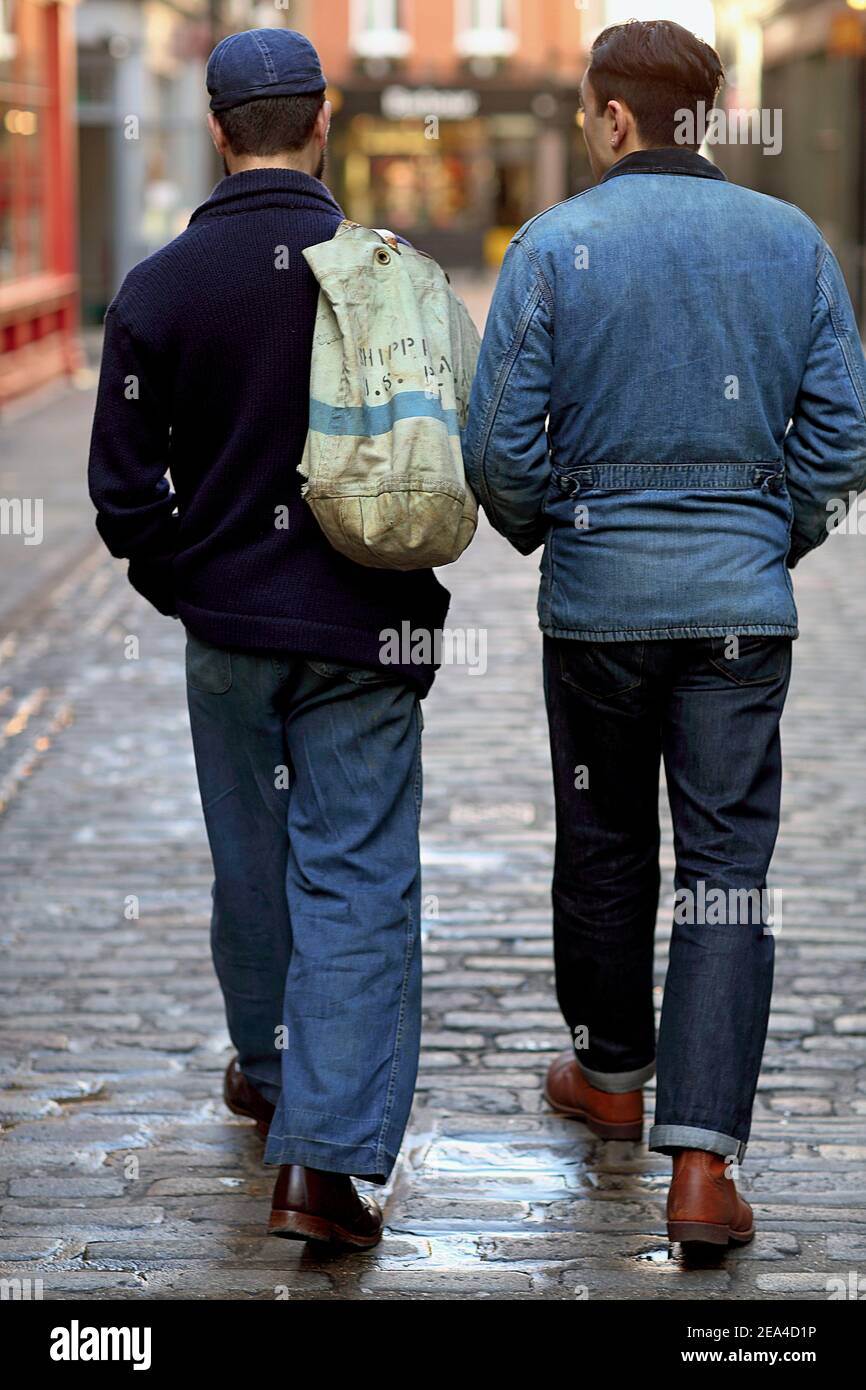 Vue arrière des amis de sexe masculin marchant dans la rue de la ville à Londres, Banque D'Images