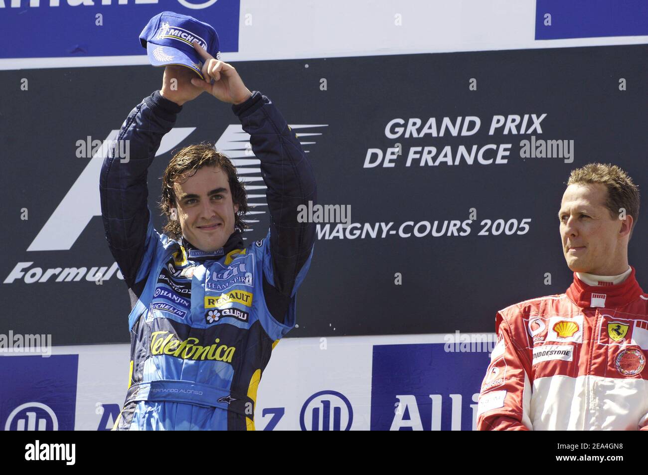 Fernando Alonso, de Renault, d'Espagne, à côté de Michael Schumacher, réagit sur le podium après le Grand Prix de France au circuit Magny cours, dans le centre de la France, le 3 juillet 2005. Alonso a remporté la course devant Kimi Raikkonen de Finlande de McLaren en deuxième place et Michael Schumacher de Ferrari en Allemagne qui a pris la troisième place. Photo de Thierry Gromik/ABACAPRESS.COM Banque D'Images