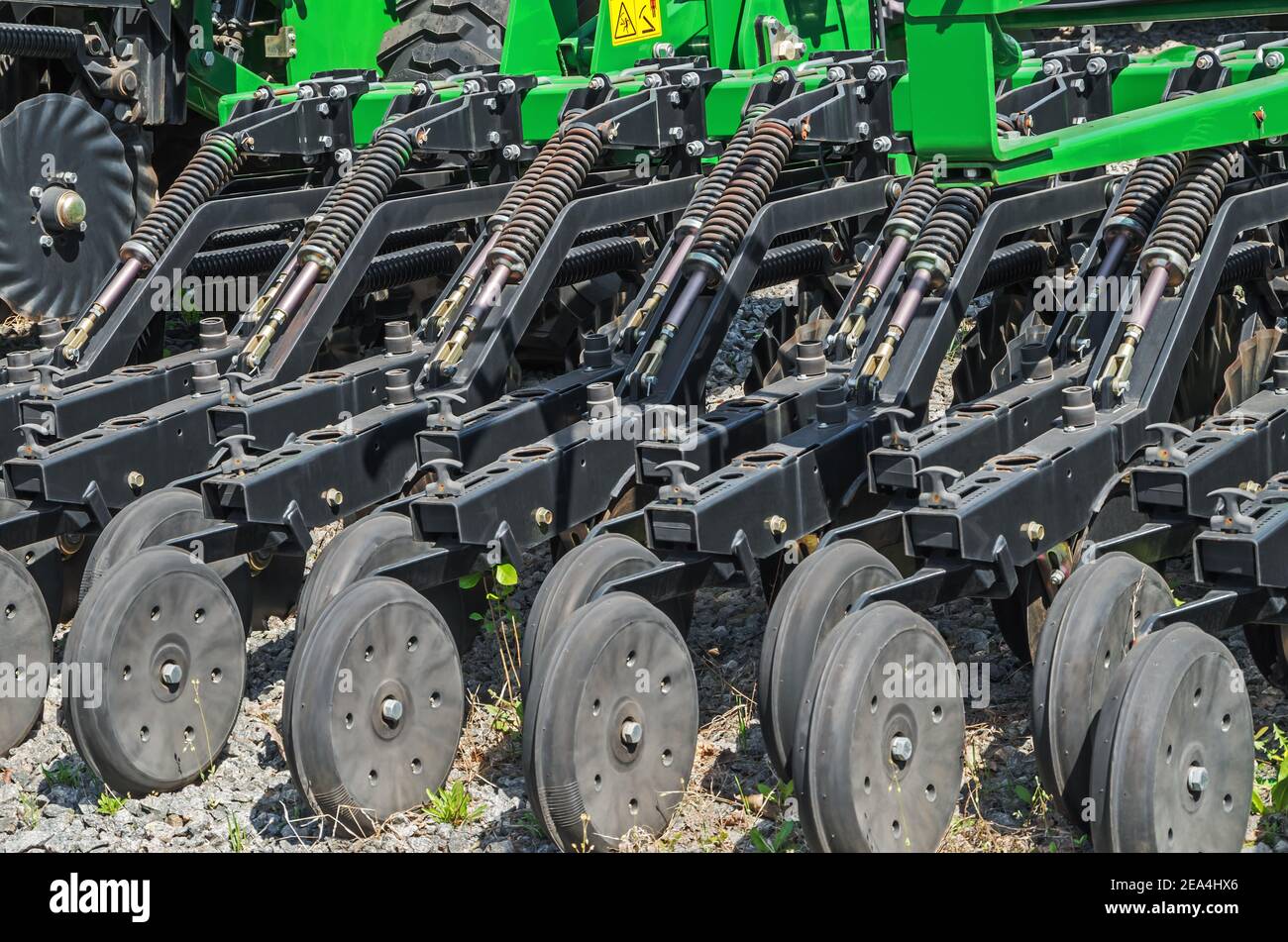 Semoir traîné préparé pour les travaux saisonniers futurs et installé pour remisage hivernal au stationnement du tracteur d'une ferme individuelle Banque D'Images