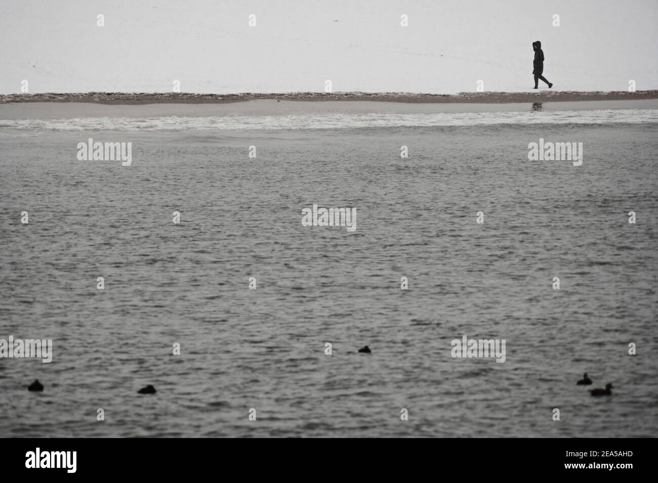 Brooklyn, New York, États-Unis. 07 février 2021, Brooklyn, New York, États-Unis. Une femme marche sur la plage enneigée de Coney Island tandis que New York fait l'expérience de sa deuxième tempête d'hiver majeure en sept jours Credit: Joseph Reid/Alay Live News Banque D'Images