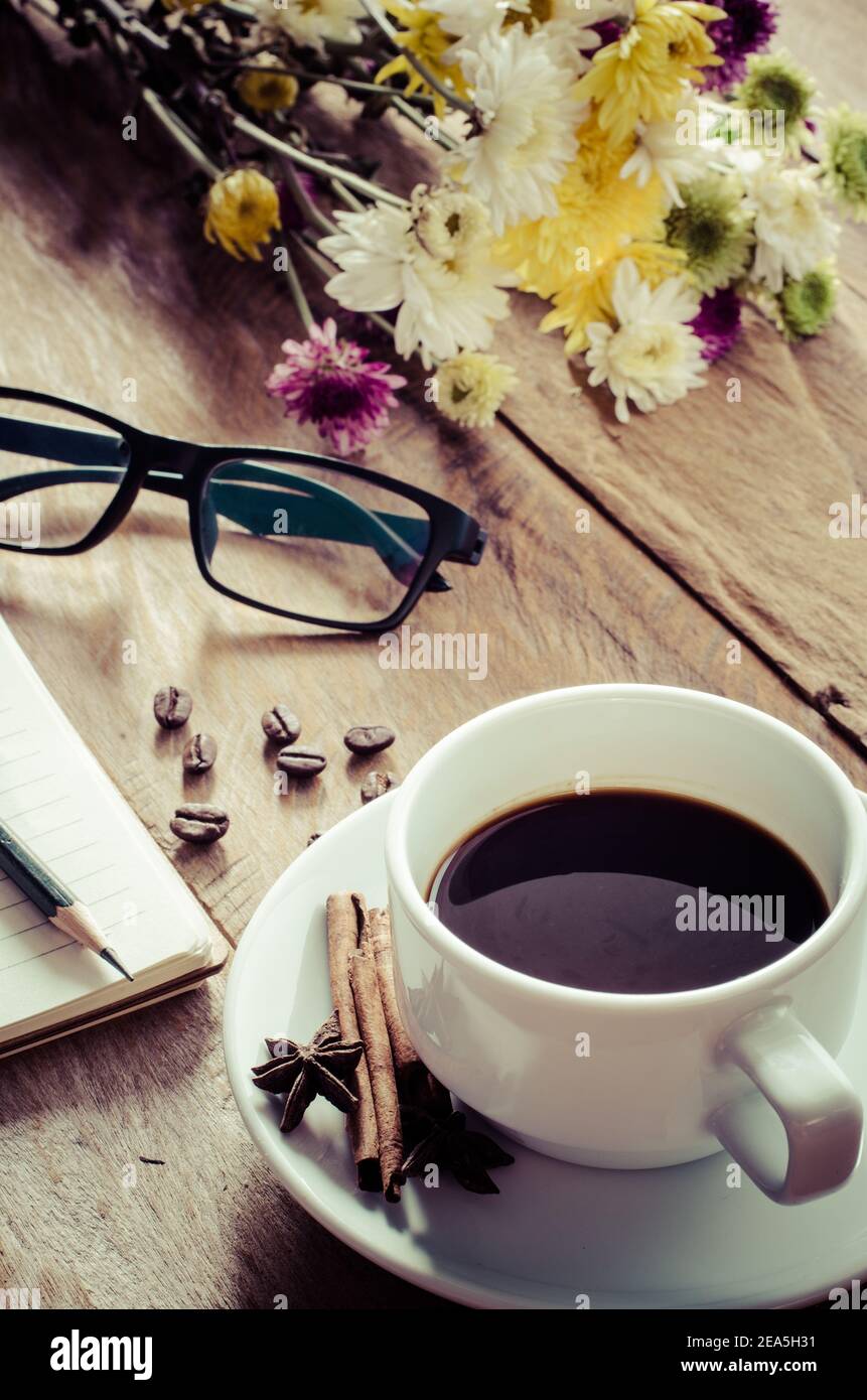 Des tasses à café et des lunettes ont placé des fleurs sur le parquet le matin. Banque D'Images