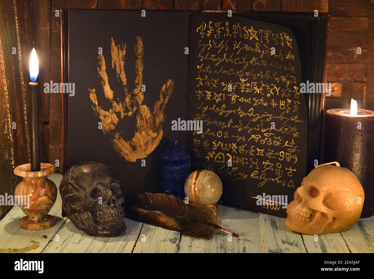 Livre ouvert avec pages noires et symboles mystiques, bougies noires et crâne sur table en bois. Vendez l'âme au concept du diable. Bac ésotérique, gothique et occulte Banque D'Images