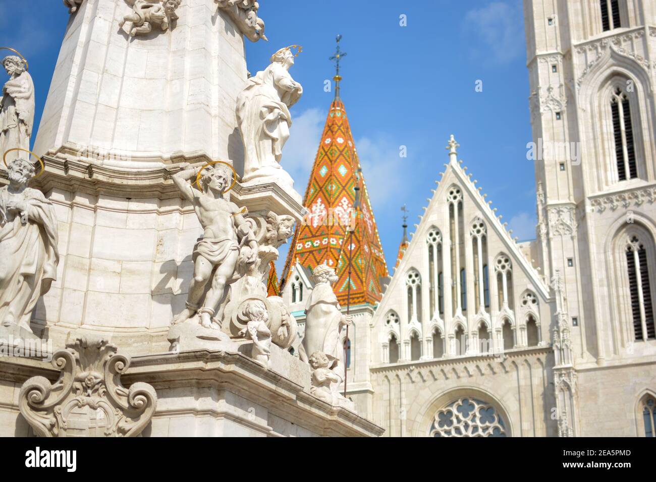 Les statues et sculptures en pierre blanche et en marbre sur le Statue de la Sainte Trinité à Budapest Hongrie avec la flèche et Façade de l'église Matthias derrière Banque D'Images