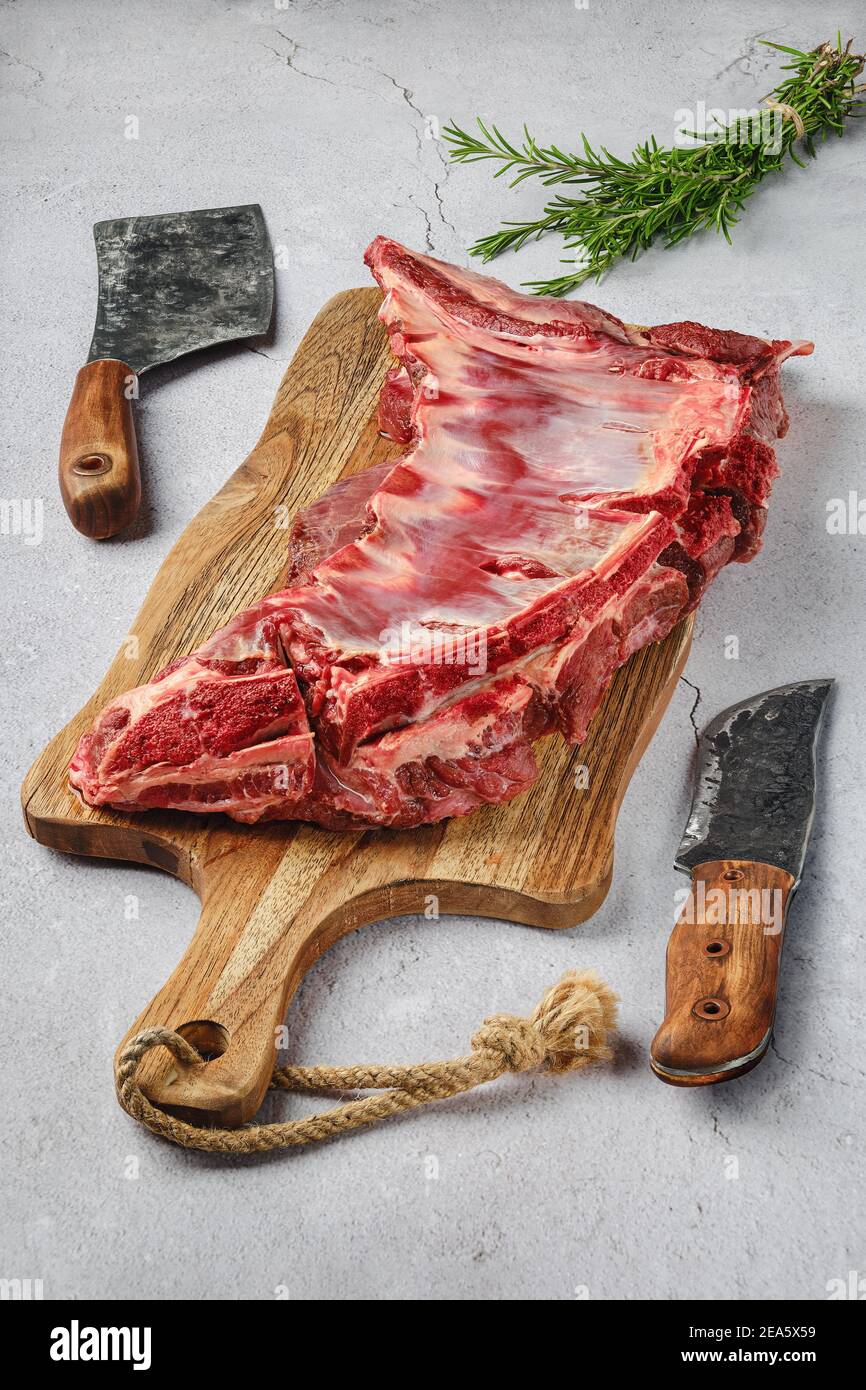Côtes de cerf frais crues avec épices et herbes sur béton arrière-plan Banque D'Images