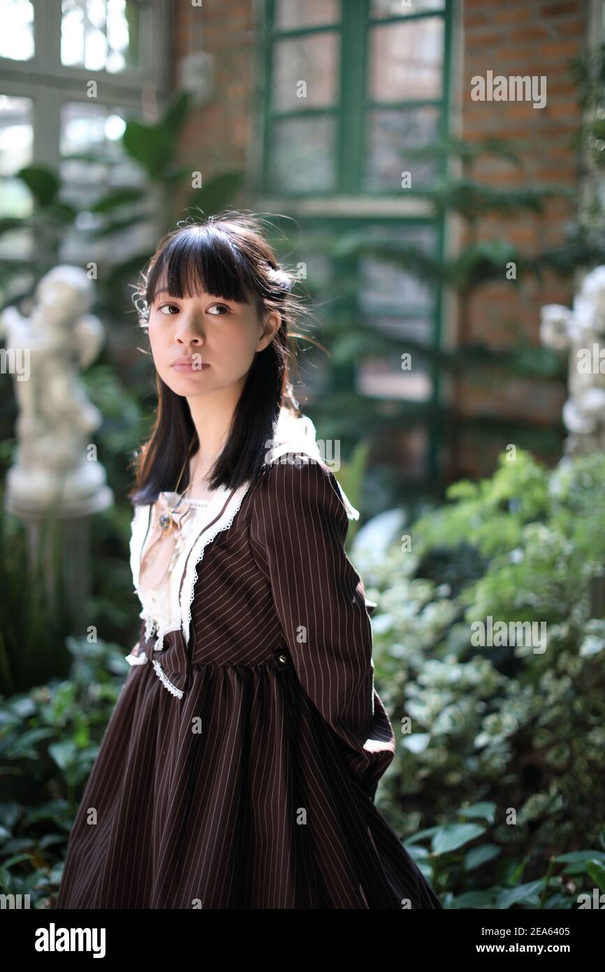 Portrait de fille asiatique avec fond de fleurs violettes Banque D'Images