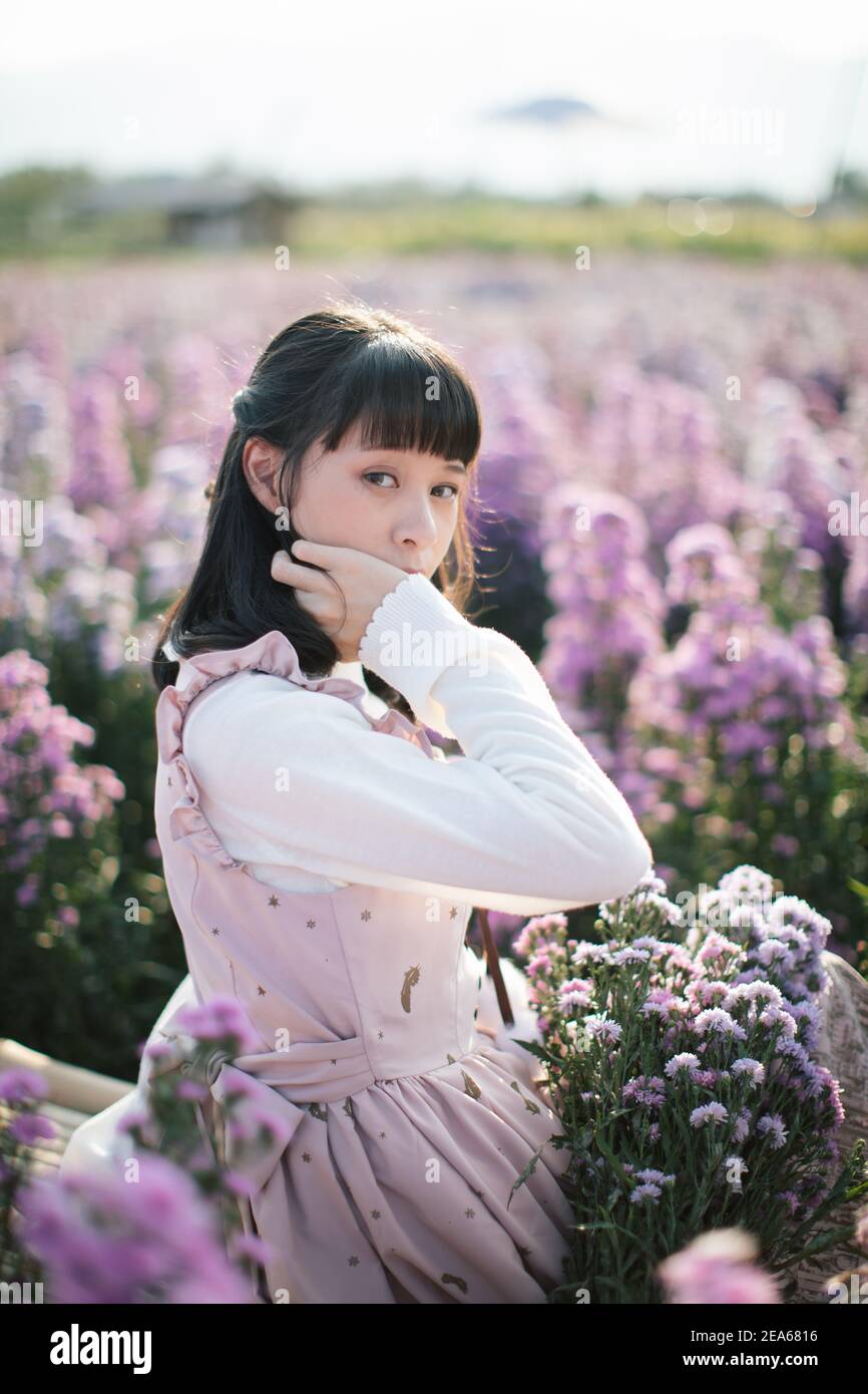 Portrait de fille asiatique avec fond de fleurs violettes Banque D'Images